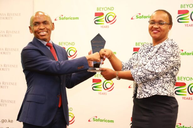 Safaricom Chief Executive Officer, Peter Ndegwa (L) receives an award from the Kenya Revenue Authority Commissioner, Domestic Taxes Department, Rispah Simiyu R